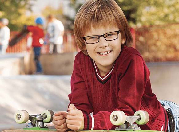 Boy enjoying his new glasses from One Hour Optical