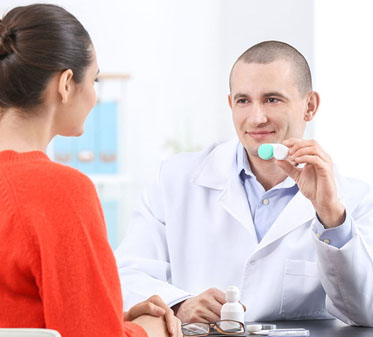 Woman getting a contact lens exam with an optometrist at One Hour Optical in IA